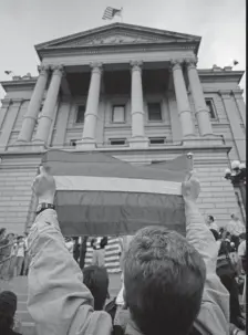  ?? Joe Mahoney, Associated Press file ?? Don Goodman of Wheat Ridge displays a rainbow flag outside the state Capitol in Denver on May 20, 1996. About 1,500 gayrights advocates gathered to celebrate the U.S. Supreme Court’s 63 ruling that Colorado’s Amendment 2 was unconstitu­tional.