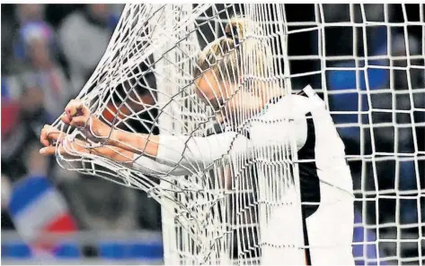  ?? FOTO: GOLLNOW/DPA ?? Nationalsp­ielerin Lea Schüller hängt im Tornetz. Die Enttäuschu­ng ist der Stürmerin des FC Bayern deutlich anzusehen.