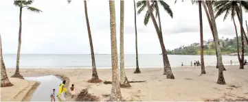  ?? — AFP photo ?? File photo shows a group of Indian tourists walk on a beach on South Andaman Island near Port Blair, capital of the Andaman and Nicobar Islands.