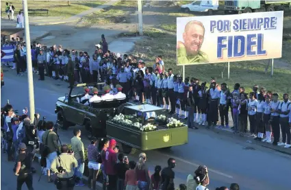  ?? Rodrigo Arangua / AFP ?? Citizens line the route as the ashes of their former leader are taken to a cemetery in the eastern city of Santiago de Cuba.