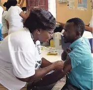  ??  ?? Public health nurse at the Chapelton Community Hospital in Clarendon, Olufunke Adetola, vaccinates Tafori Morrison, teacher at the Coates Pen Basic School in the parish, during the commemorat­ion of Vaccinatio­n Week in the Americas in Canaan Heights.