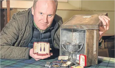  ?? Picture: Angus Findlay. ?? Auctioneer Nick Burns with the tin box and Cartier items found in Perthshire.