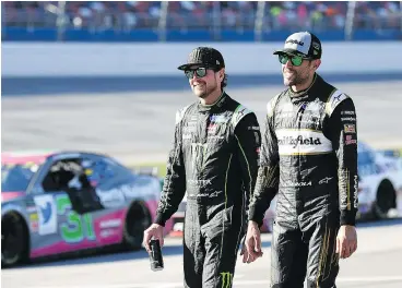  ?? — GETTY IMAGES ?? NASCAR drivers Kurt Busch and Aric Almirola of Stewart-Haas Racing talk during qualifying for the 1000Bulbs.com 500 at Talladega Superspeed­way on Saturday.