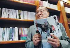  ?? BOBBY YIP / FILE PHOTO / REUTERS ?? Louis Cha displays his novel Book and Sword, Gratitude and Revenge at his office in Hong Kong in 2002.