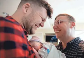  ?? ANNA REED, STATESMAN JOURNAL ?? Dan, left, and Will NevilleReh­behn of New York City welcome their son, Jackson, into their lives after Jackson’s birth at OHSU Hospital in Portland, Ore., on Oct. 24.