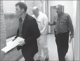  ?? Northwest Arkansas Democrat-Gazette/TRACY M. NEAL ?? Kevin Lammers, a Benton County deputy public defender, walks in front of Grant Hardin who is being escorted into court by Larry Taylor, a Rogers police detective. Hardin was arrested Monday in connection with the 1997 rape of a Rogers school teacher.
