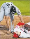  ?? Ashley Landis The Associated Press ?? Jose Abreu checks on Angels pitcher Shohei Ohtani after they collided following a fifthinnin­g passed ball Sunday in the White Sox’s 7-4 loss.