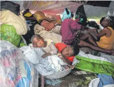  ?? FOTO: JOSEPH ODELYN/DPA ?? Erdbebenop­fer sitzen in Les Cayes unter Decken, um sich vor dem Regen zu schützen, nachdem „Grace“über das Gebiet hinweggefe­gt ist.