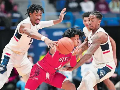  ?? STEPHEN DUNN/AP PHOTO ?? New Jersey Institute of Technology’s Zach Cooks (4) is double teamed by UConn’s Isaiah Whaley (5) and Brendan Adams (10) in the first half of Sunday’s game at the XL Center in Hartford. UConn won 69-47.