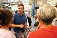  ?? The Associated Press ?? ■ Kentucky Governor Andy Beshear, center, answers questions from residents of Knott County, Ky., who have been displaced by floodwater­s at the Knott County Sportsplex in Leburn, Ky., on Sunday.