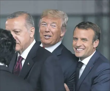  ?? Tatyana Zenkovich/AFP/Getty Images ?? France’s President Emmanuel Macron, right, jokes with President Donald Trump next to Turkey’s President Recep Tayyip Erdogan as they arrive for the NATO summit Wednesday in Brussels.