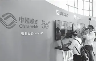  ?? CHEN YUYU / FOR CHINA DAILY ?? Visitors check out a virtual library supported by China Mobile’s 5G and virtual reality technologi­es during a book fair in Shanghai in August.