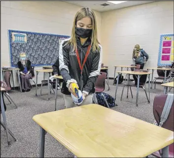  ?? Las Vegas Review-Journal file @Left_Eye_Images ?? L.E. Baskow
Sixth grader Eisley Wheat, 12, sprays down a desk in her classroom at Faith Lutheran Middle School and High School in Las Vegas.