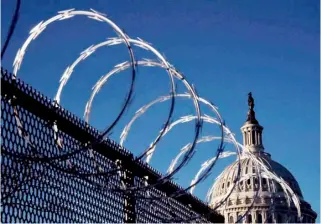  ?? OLIVIER DOULIERY/AGENCE FRANCE-PRESSE ?? Like a garrison Razor wire remains atop a security fence outside the US Capitol in Washington, D.C. even as acting Capitol police chief Yogananda Pittman testifies Thursday in a congressio­nal hearing on the 6 January attack by supporters of then-president Donald Trump.