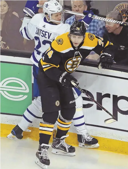  ?? STAFF PHOTO BY STUART CAHILL ?? TAKING A PHYSICAL: Jake DeBrusk hits Maple Leafs defenseman Nikita Zaitsev during last night’s Game 5 between the Bruins and Toronto at the Garden.