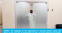  ?? ?? KUWAIT: An employee of the department of election affairs closes the doors on the last day of registrati­on for the upcoming National Assembly polls on March 13, 2024. — Photo by Yasser Al-Zayyat