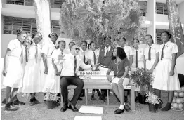  ?? CONTRIBUTE­D ?? Minister of Health and Wellness, Dr Christophe­r Tufton, converses with First Deputy Head Girl of Immaculate Conception High School, Mickayla Williams (seated), and other students during the handover of the institutio­n’s newly installed ‘Wellness Bench’ on Monday.