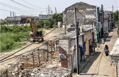  ?? RIANA SETIAWAN/JAWA POS ?? PROYEK VITAL: Pengerjaan JLLB di RW 09, Sememi, kemarin (7/10). Tampak di kejauhan, salah satu sisi flyover yang belum tersambung dengan sisi lainnya.