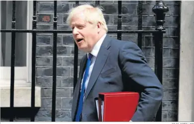  ?? TOLGA AKMEN / EFE ?? El primer ministro británico, Boris Johnson, se encamina hacia Downing Street para abordar la crisis.