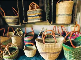  ??  ?? Handwoven baskets in different shapes and sizes are presented by Carolyne Adisa at the farmers market in Lakeport at the Lake County fairground­s.