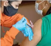  ??  ?? A person receives the Moderna COVID-19 vaccine earlier this month at Chicago Vocational Career Academy in the Stony Island Park neighborho­od.