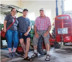  ??  ?? In der Garage von Andreas Huber (Mitte), einem „Freund alter Landmaschi­nen“. Mit auf dem Bild Anja Stehle und Hubers Onkel Konrad.