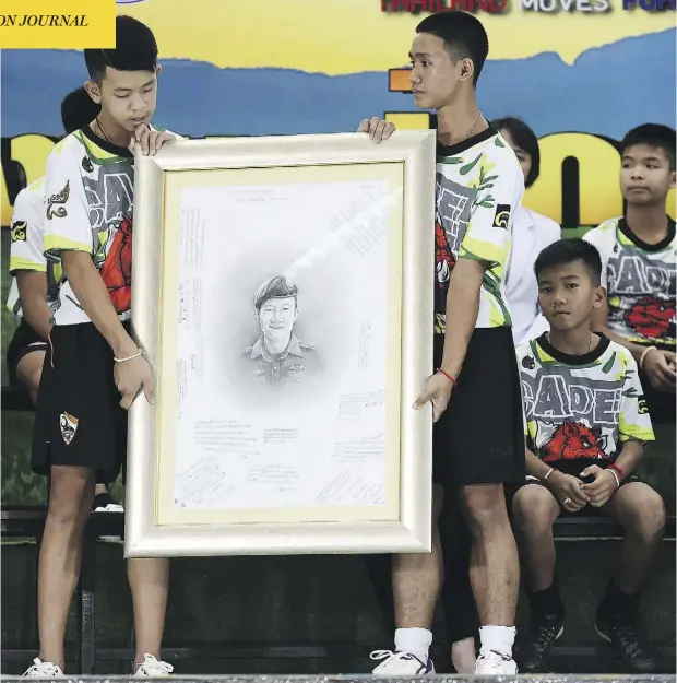  ?? LILLIAN SUWANRUMPH­A/AFP/GETTY IMAGES ?? Members of the Wild Boars soccer team pay tribute to former Thai Navy SEAL diver Saman Kunan, who died helping prepare their rescue operation, at a press conference in Chiang Rai, Thailand, on Wednesday. It marked the first time the team has appeared in public since their ordeal ended.