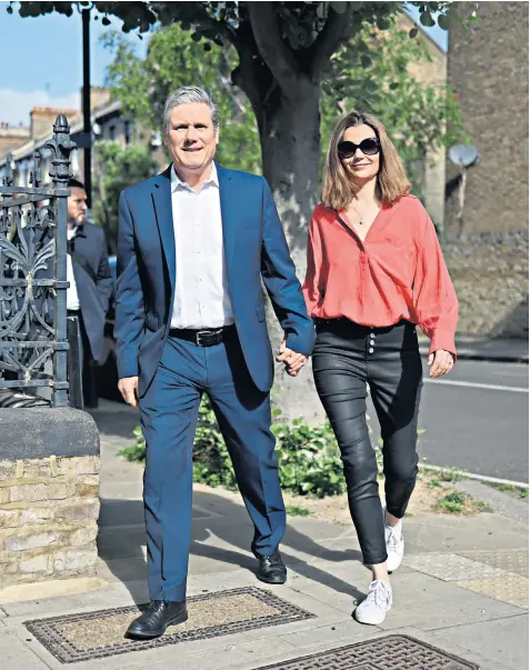  ?? ?? Sir Keir Starmer heads to a polling station near his home in north-west London to cast his vote in local elections with his wife Victoria