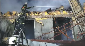  ?? UKRAINIAN EMERGENCY SERVICE VIA ASSOCIATED PRESS ?? Firefighte­rs work on the site of a burning building destroyed during an attack in Odesa on Friday.