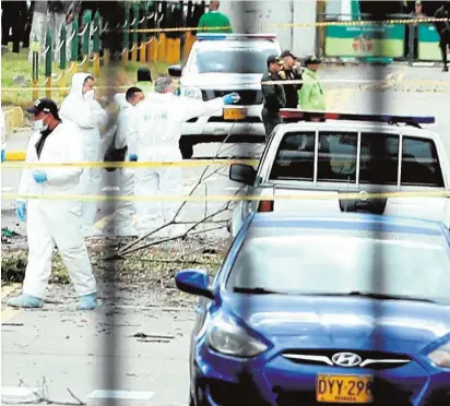  ?? EFE ?? Investigad­ores, en el lugar donde explotó un vehículo bomba en la Escuela de la Policía en Bogotá