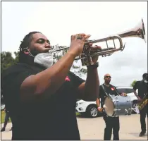  ??  ?? A performer plays his trumpet.