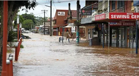  ?? PHOTO: MARC STAPELBERG ?? Floodwater tears through the Lismore central business district.