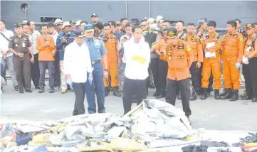  ??  ?? Indonesian President Joko Widodo (front, second right), Indonesia’s Minister of Transporta­tion Budi Karya Sumadi (front, left) and Syaugi (front, right) tour the operations centre as recovered debris from the ill-fated Lion Air flight JT 610 are laid out at a port in northern Jakarta.