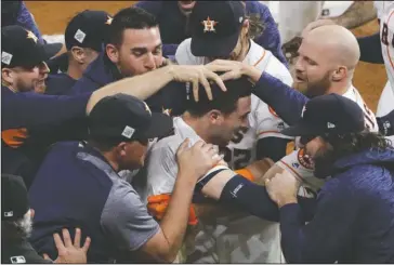  ?? The Associated Press ?? NO PLACE LIKE HOME: Houston teammates mob Alex Bregman after he drives home the winning run in the 10th inning of World Series Game 5 early Monday. The Astros overcame 4-0 and 7-4 deficits against Clayton Kershaw to win 13-12 and take a 3-2 lead in the...