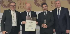  ??  ?? Louis A. Farrugia, chairman of the Farsons Group and Ray Sciberras, consultant engineer, accepting the bronze medal awarded to Farsons Blue Label Ale in this year’s European Beer Star Awards during a presentati­on held in Nuremberg, Germany. Georg Rittmayer, president Private Brauereien Bayern e.V. (left) and Detlef Projahn, president Private Brauereien Deutschlan­d e.V. presented the award