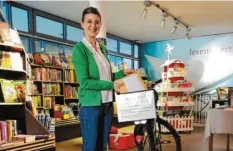  ?? Foto: Alexandra Behr ?? Saskia Kaiser-Bichler (Buchhändle­rin von Lesenswert in Friedberg) lädt Päckchen in einen Fahrradkor­b, damit sie ausgeliefe­rt werden können.