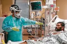  ?? Melissa Phillip / Staff file photo ?? Physical therapy technician Carlos Martinez works with COVID patient Jose Gil Suarez at Houston Methodist Hospital.