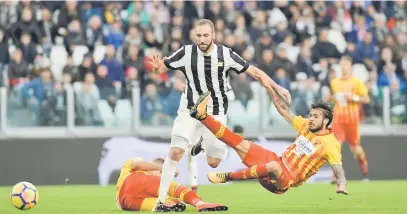  ?? — Gambar AFP ?? LASAK: Higuain (tengah) begelut melepasi kawalan dua pemain Benevento ketika beraksi pada perlawanan di Stadium Juventus, Turin pada Ahad lepas.