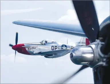  ?? Westside Eagle Observer/MIKE ECKELS ?? A P-51 Mustang out of Bentonvill­e flies alongside the B-29 on Friday during a portion of the flight. A pair of the fighters escorted “Doc,” the large B-29, in the Lost Bridge area.