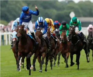  ?? Reuters ?? Sheikh Hamdan bin Mohammed bin Rashid Al Maktoum, Crown Prince of Dubai, holds the trophy as Princess Anne looks on. Right: William Buick on Blue Point celebrates winning the race at Royal Ascot on Tuesday. —