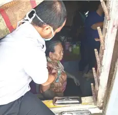  ??  ?? A medical staff jabs an elderly woman through the window of her unit.