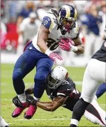  ?? RICK SCUTERI / ASSOCIATED PRESS 2015 ?? Former Rams running back and UGA star Todd Gurley (30) and former Cardinals linebacker Deone Bucannon (making tackle), who spent last season with the Giants and the Bucs, are among those newcomers the Falcons would like to assess and acclimate at minicamp, should the league give the go-ahead for starting dates.