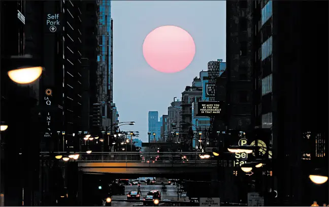  ?? JOHN J. KIM/CHICAGO TRIBUNE ?? The sun sets over West Madison Street on the autumnal equinox, Sept. 22, in Chicago.