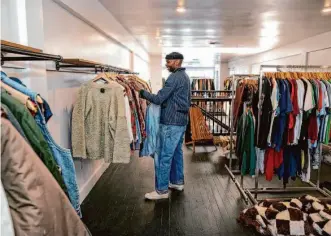  ?? Photos by Salgu Wissmath/The Chronicle ?? Above: ReLove general manager Michael Hillord organizes clothes at ReLove’s Oakland location, which will open Feb. 18 at 3258 Grand Ave. ReLove is a sustainabl­y sourced resale shop specializi­ng in vintage and designer clothes. Below: ReLove owner Delila Hailechris­tos.