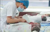  ?? PEI QIANG / FOR CHINA DAILY ?? A medical worker attends to newborns at Gansu Women and Children’s Hospital in Gansu province on Feb 28.
