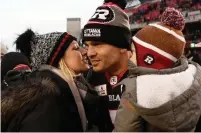  ?? JUSTIN TANG THE CANADIAN PRESS ?? Ottawa Redblacks Trevor Harris gets a kiss from his wife, Kalie, after leading a blowout victory over Hamilton on Sunday.