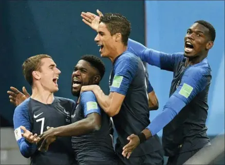  ?? MARTIN MEISSNER — THE ASSOCIATED PRESS ?? France’s Samuel Umtiti, second from left, is congratula­ted by his teammates France’s Antoine Griezmann, Raphael Varane and Paul Pogba, from left, after scoring the opening goal during the semifinal match between France and Belgium at the 2018soccer World Cup in the St. Petersburg Stadium in St. Petersburg, Russia, Tuesday.