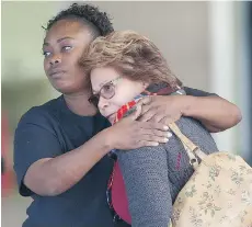  ?? JAE C. HONG/THE ASSOCIATED PRESS ?? Two women embrace at a community centre where family members gathered to pick up survivors after a shooting rampage at a social services centre in San Bernardino, California on Wednesday.