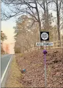  ?? Morgan Popham ?? The sign wrapped in a purple bow placed to honor Alex Crumbley now sits toward the top of Ward Mountain Road. It reads “Drive safely, in memory of Alex Crumbley.”