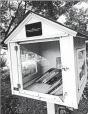  ?? MICHAEL E. MILLER/WASHINGTON POST PHOTOS ?? This Little Free Library dedicated to Michelle Obama has been vandalized several times. Above, the glass and door were broken. Later, vandals wrote Trump’s name on it.